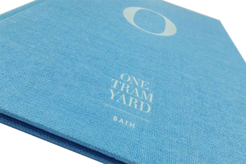 Thin hardcover book covered with a blue fabric.